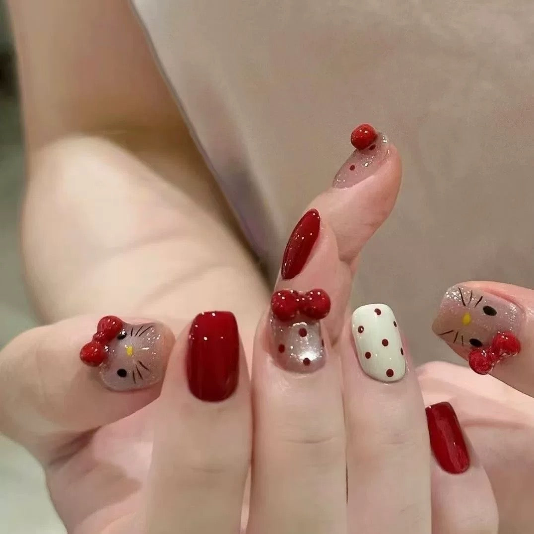Press-on nails featuring polka dots, cat-eye effect, and bow accents.
