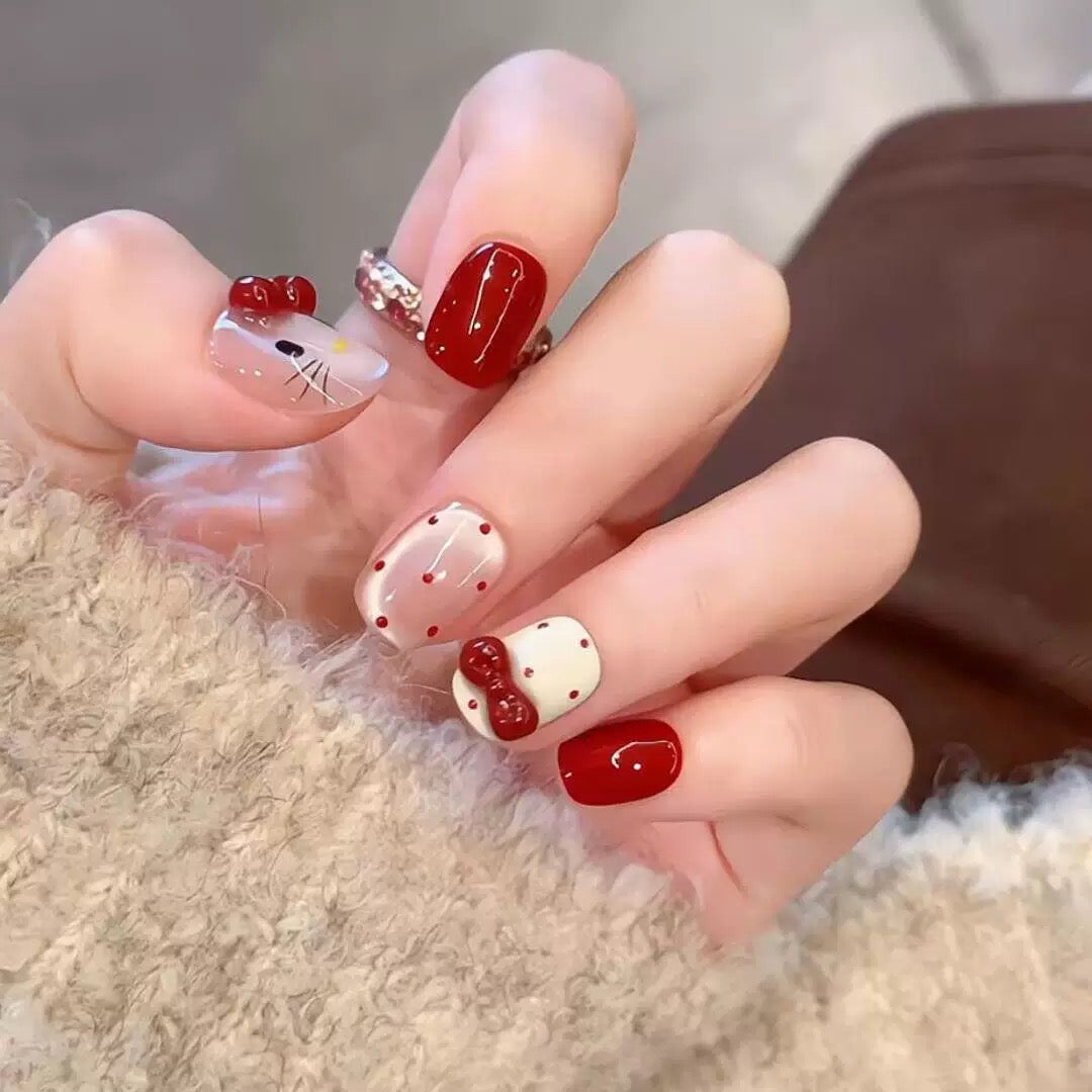 Press-on nails featuring polka dots, cat-eye effect, and bow accents.