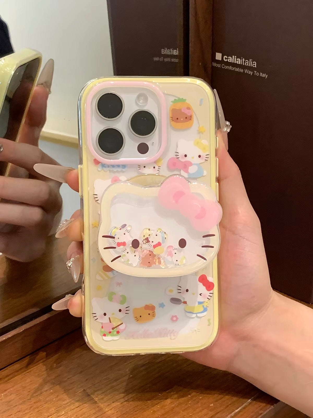 Phone case with yellow trim, kitten design, and built-in magnetic stand for daily use.