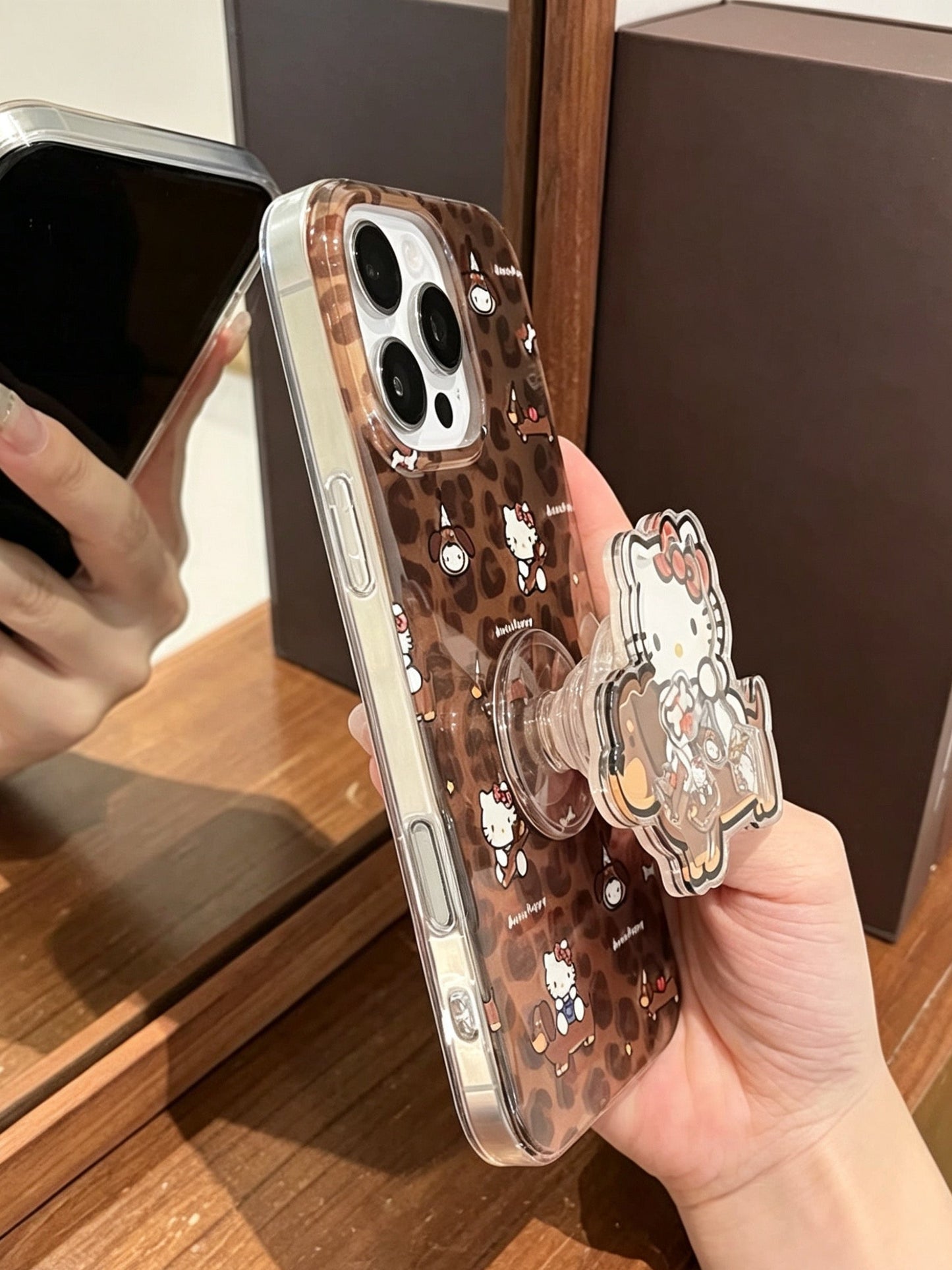 Brown leopard-print phone case featuring a dachshund and Hello Kitty, with a built-in stand.