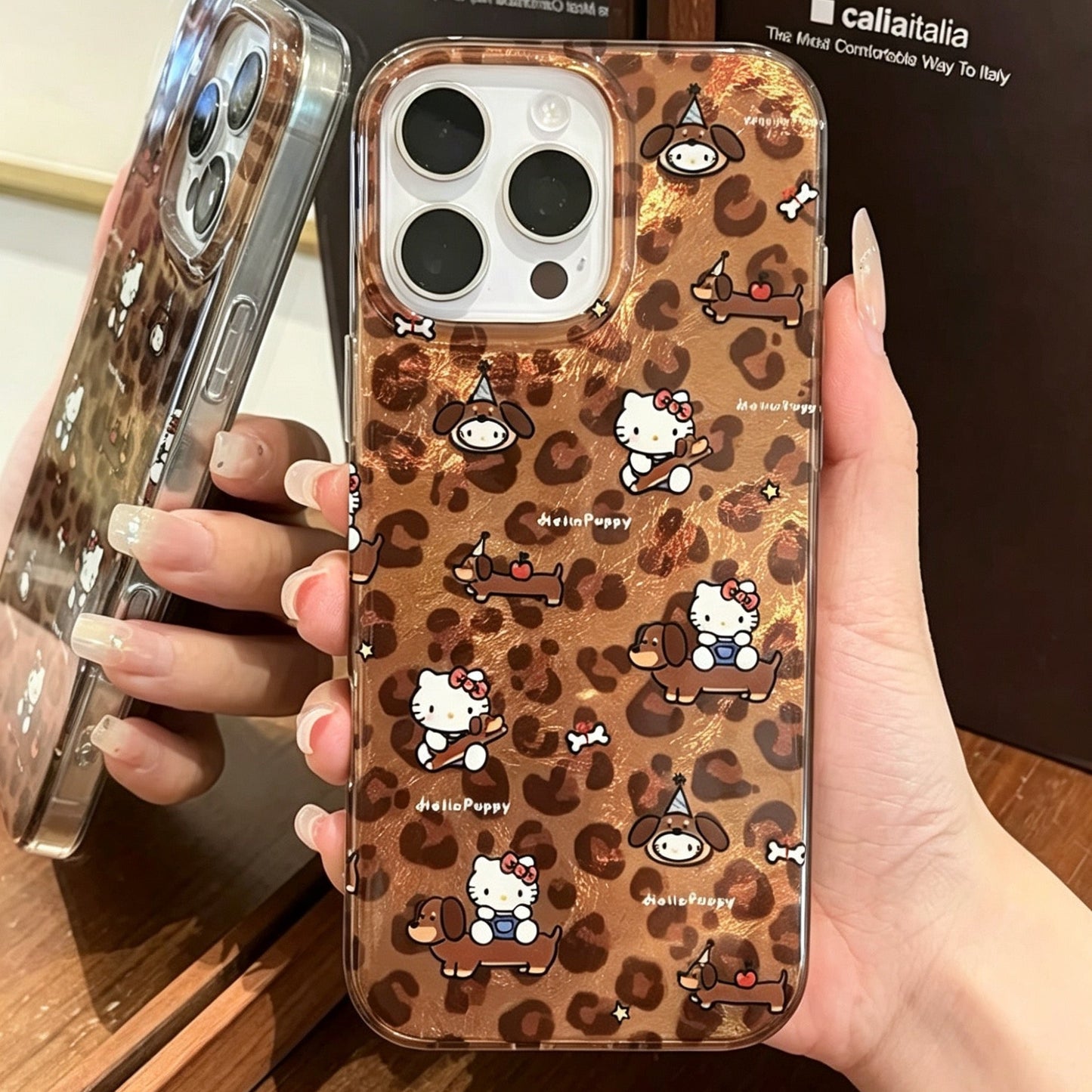Brown leopard-print phone case featuring a dachshund and Hello Kitty, with a built-in stand.