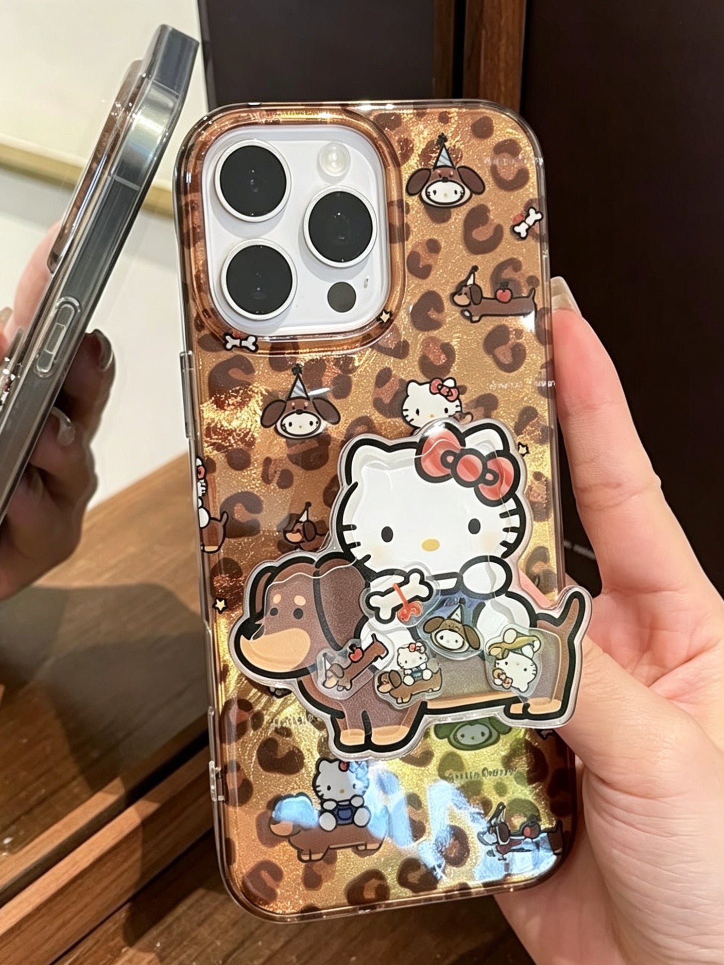 Brown leopard-print phone case featuring a dachshund and Hello Kitty, with a built-in stand.
