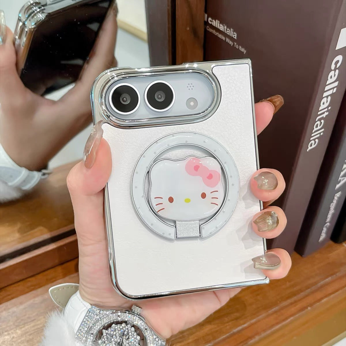 Minimalist solid-color leather-style folding phone case for iPhone Duo featuring a magnetic stand and a cartoon Hello Kitty design.