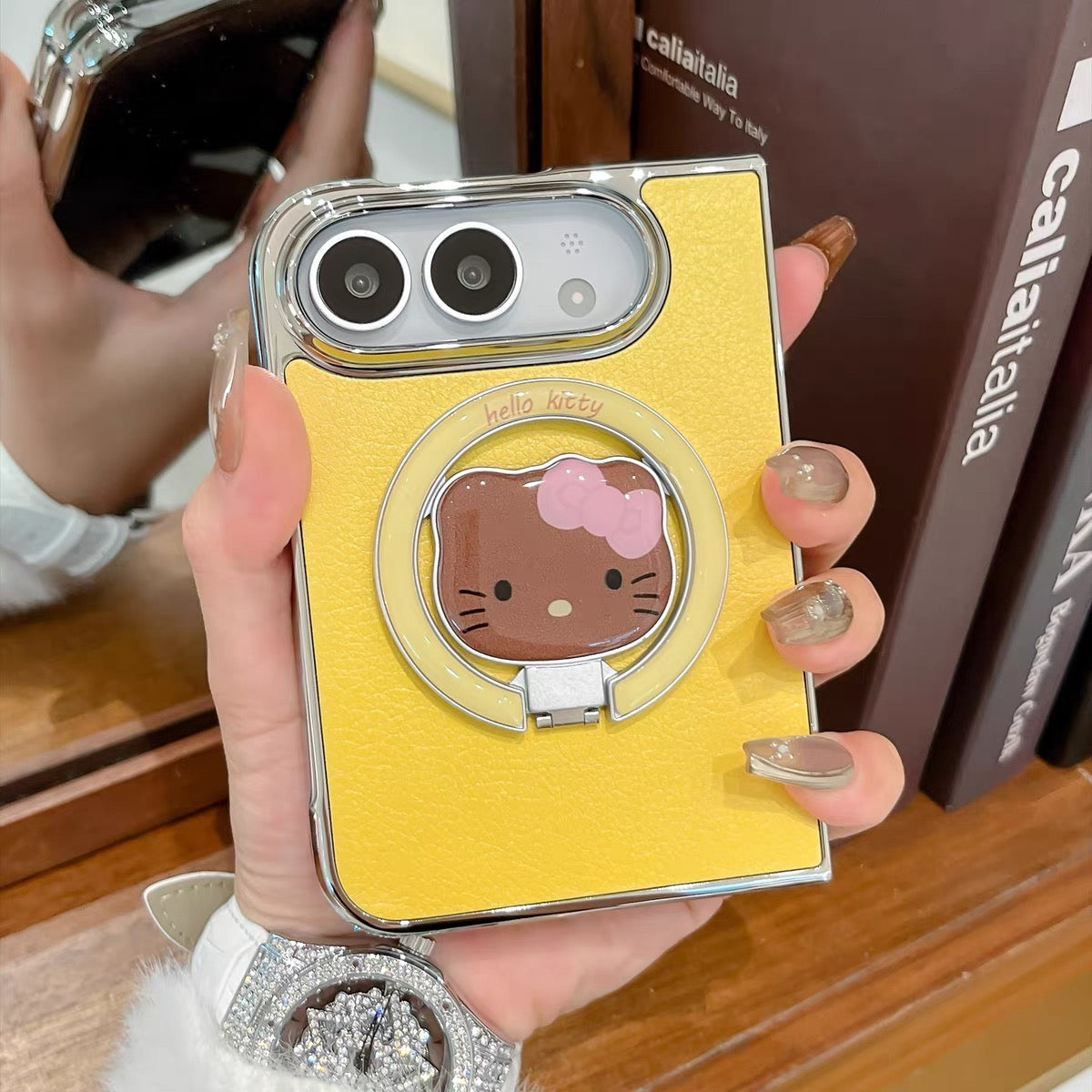 Minimalist solid-color leather-style folding phone case for iPhone Duo featuring a magnetic stand and a cartoon Hello Kitty design.
