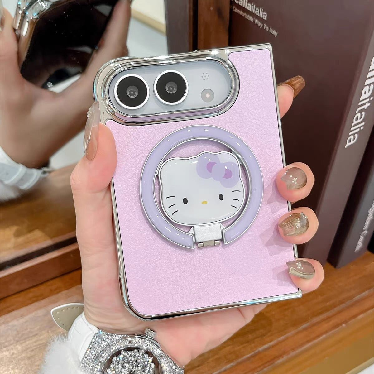 Minimalist solid-color leather-style folding phone case for iPhone Duo featuring a magnetic stand and a cartoon Hello Kitty design.