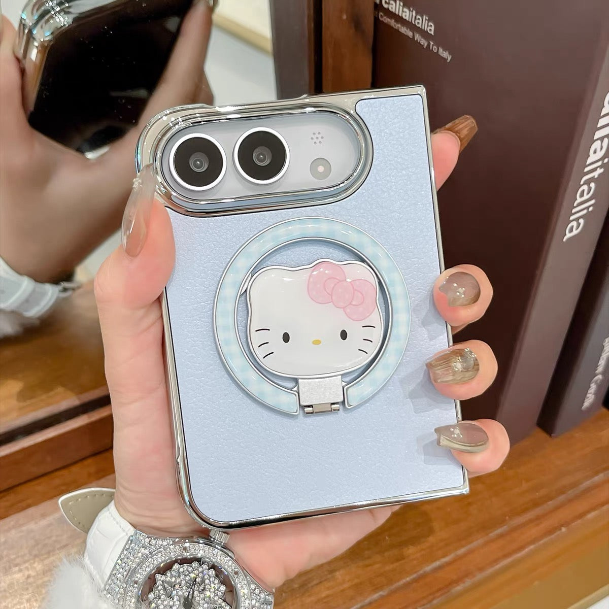 Minimalist solid-color leather-style folding phone case for iPhone Duo featuring a magnetic stand and a cartoon Hello Kitty design.