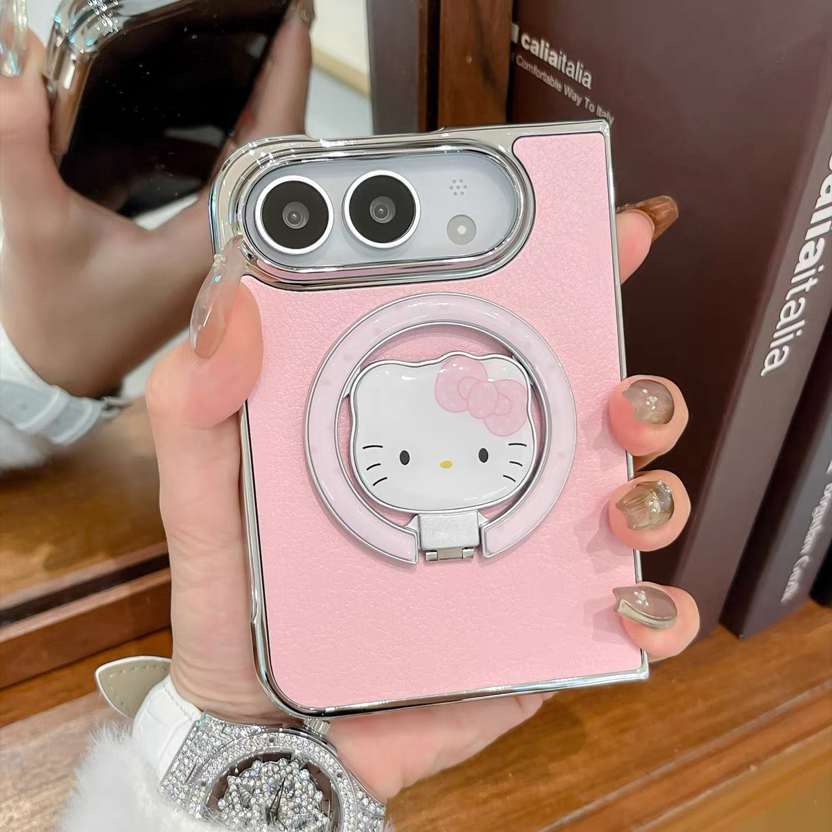 Minimalist solid-color leather-style folding phone case for iPhone Duo featuring a magnetic stand and a cartoon Hello Kitty design.