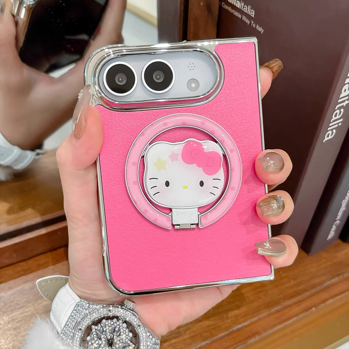 Minimalist solid-color leather-style folding phone case for iPhone Duo featuring a magnetic stand and a cartoon Hello Kitty design.