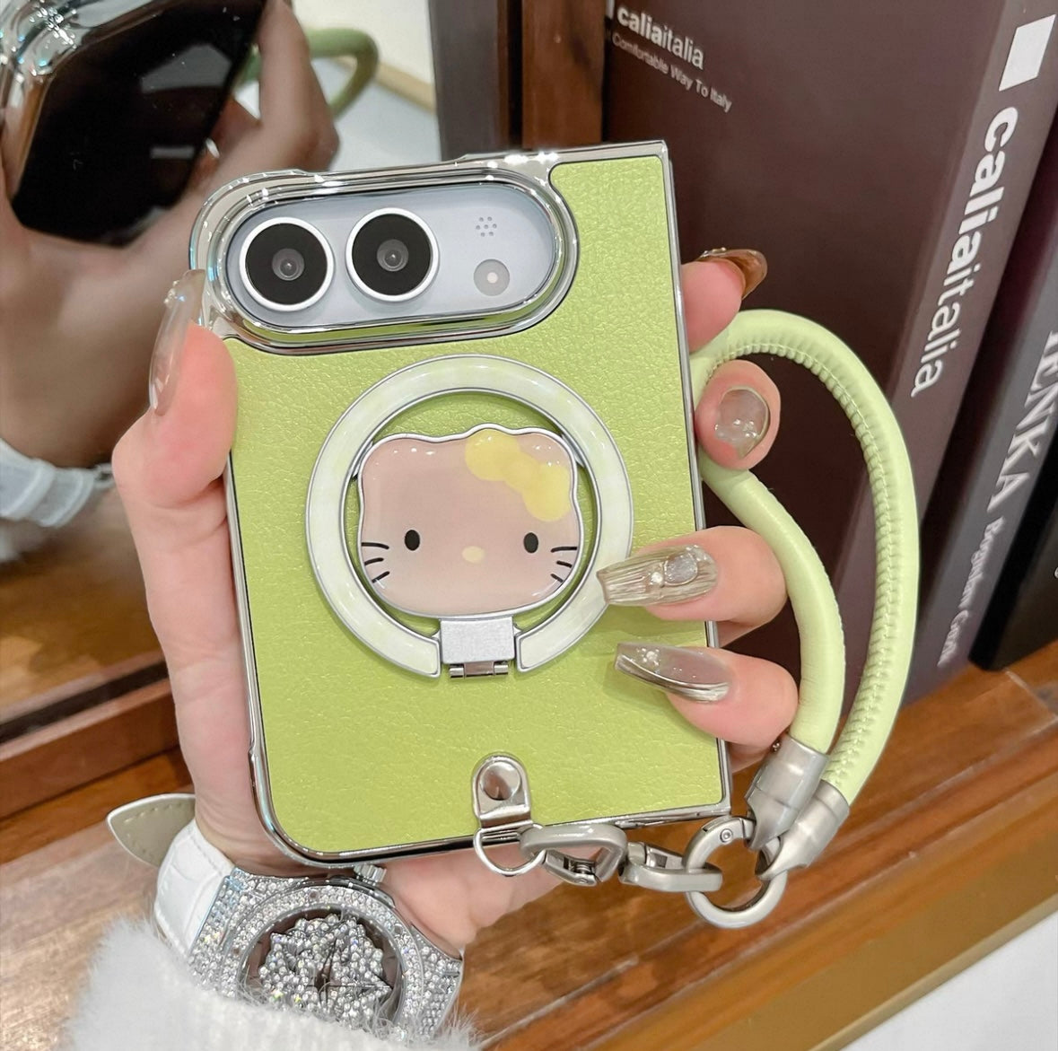 Minimalist solid-color leather-style folding phone case for iPhone Duo featuring a magnetic stand and a cartoon Hello Kitty design.