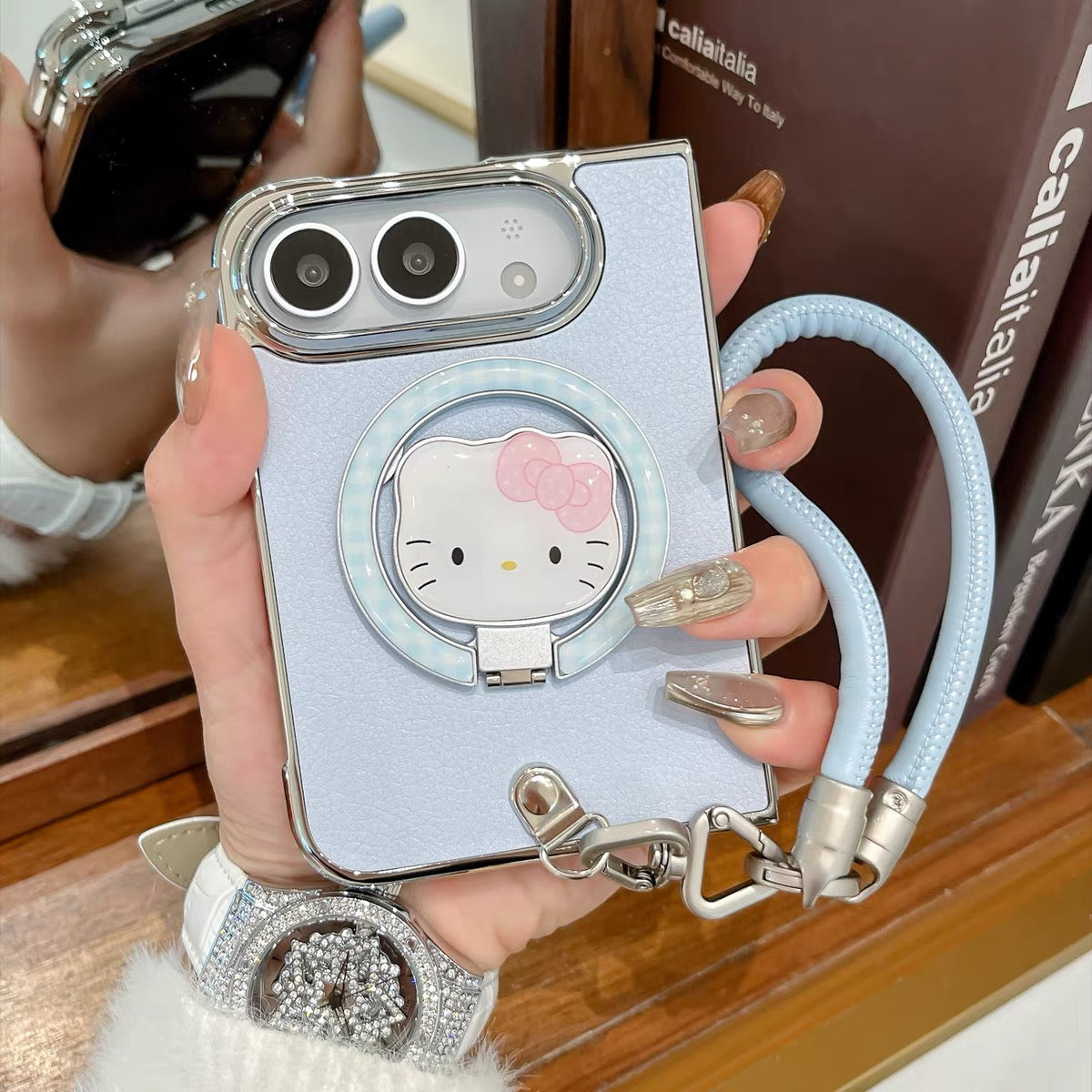 Minimalist solid-color leather-style folding phone case for iPhone Duo featuring a magnetic stand and a cartoon Hello Kitty design.