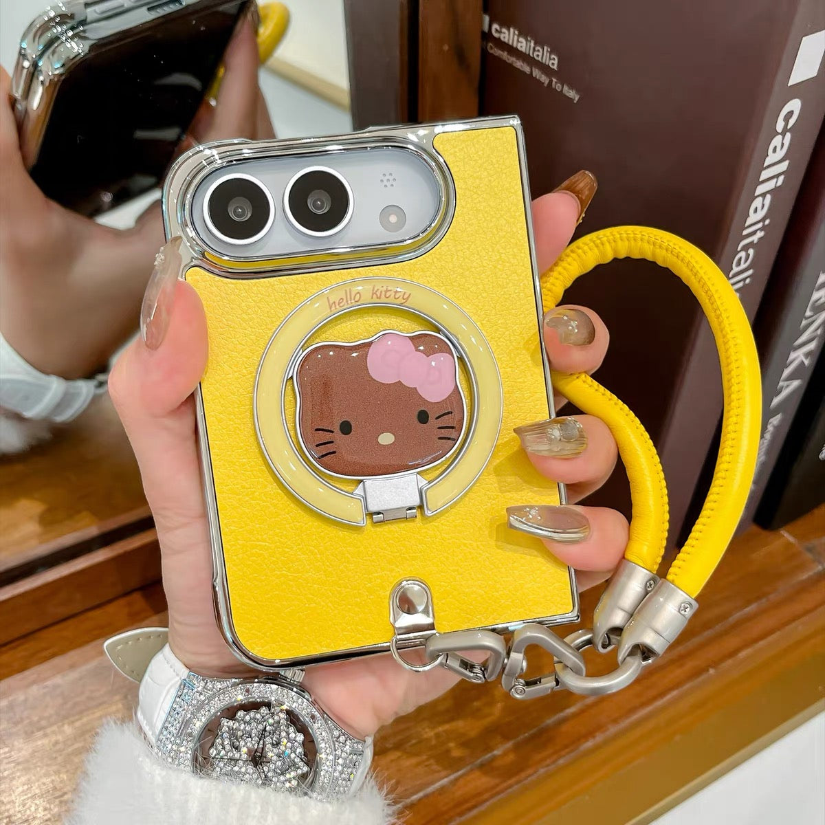 Minimalist solid-color leather-style folding phone case for iPhone Duo featuring a magnetic stand and a cartoon Hello Kitty design.