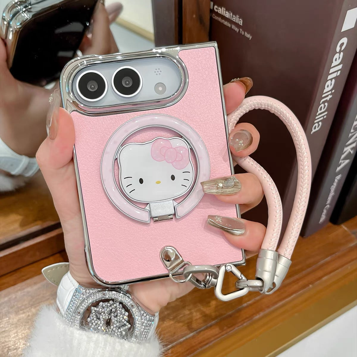 Minimalist solid-color leather-style folding phone case for iPhone Duo featuring a magnetic stand and a cartoon Hello Kitty design.