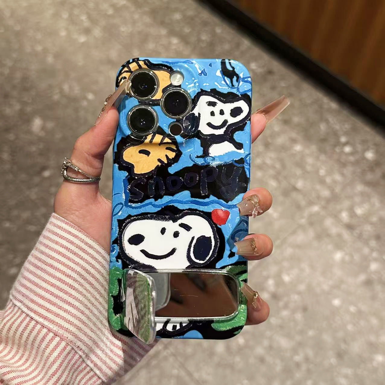 Doodle-style Snoopy phone case with a mirror stand